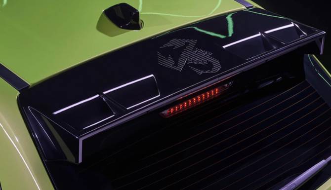 Close-up of a car spoiler with a distinctive logo and integrated brake light.