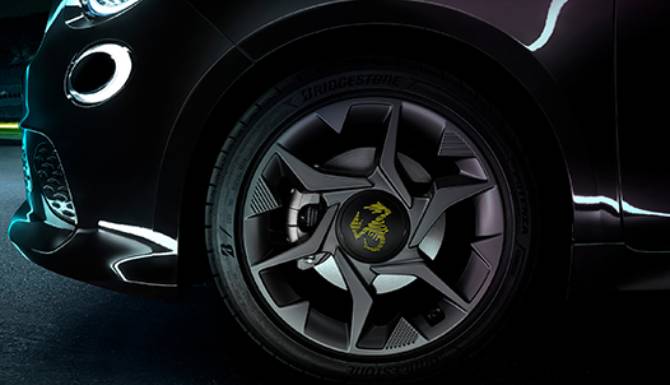 Close-up of a car wheel with a black alloy rim and a logo in the centre.