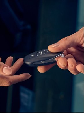 person handing over a key to another person