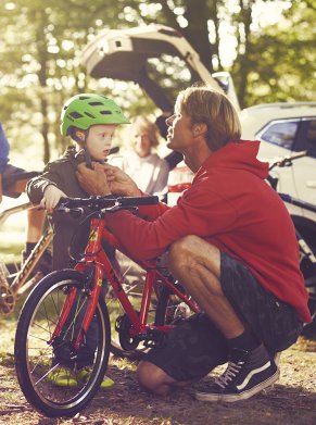 a man putting a helmet on the child