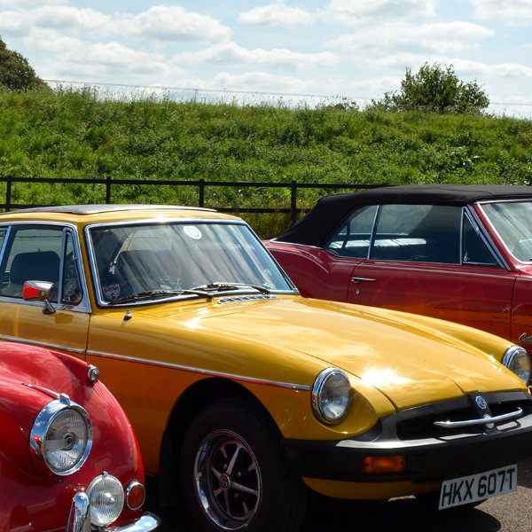 Vintage yellow and red cars parked side by side.