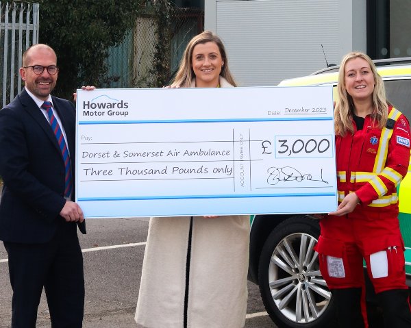 Three people holding a large cheque for £3,000 to Dorset & Somerset Air Ambulance.