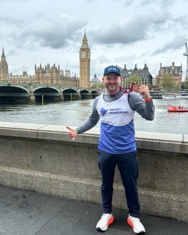 Man with a medal in front of Big Ben and Westminster Bridge in London.