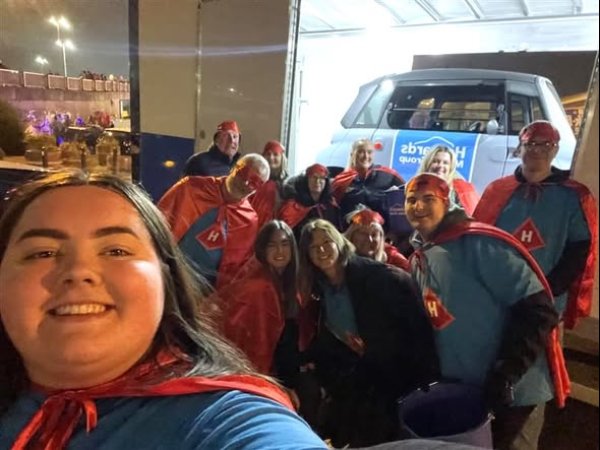 Group of people in superhero-themed costumes posing for a selfie.