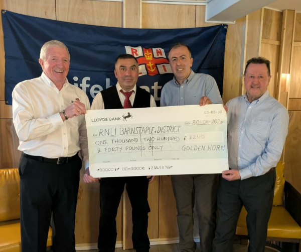 Four men holding a large cheque for £1,240 payable to RNLI Barnstaple and District.