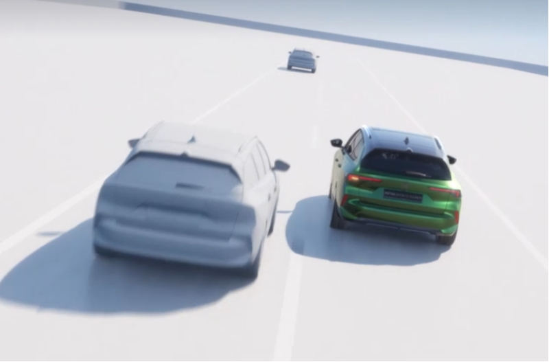 Green car overtaking a grey car on a multi-lane road.