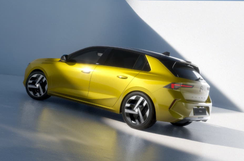 Yellow hatchback car with modern design and sleek black roof viewed from the side.