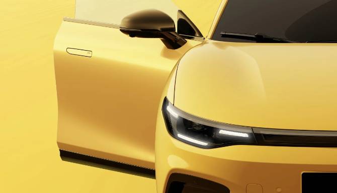Yellow car with open driver's door, showing front headlights.