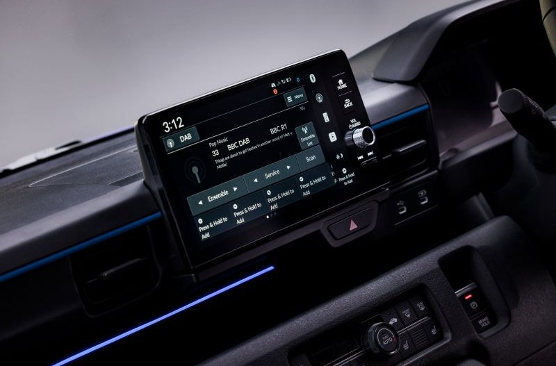 Car dashboard with a digital display showing radio settings at 3:12.