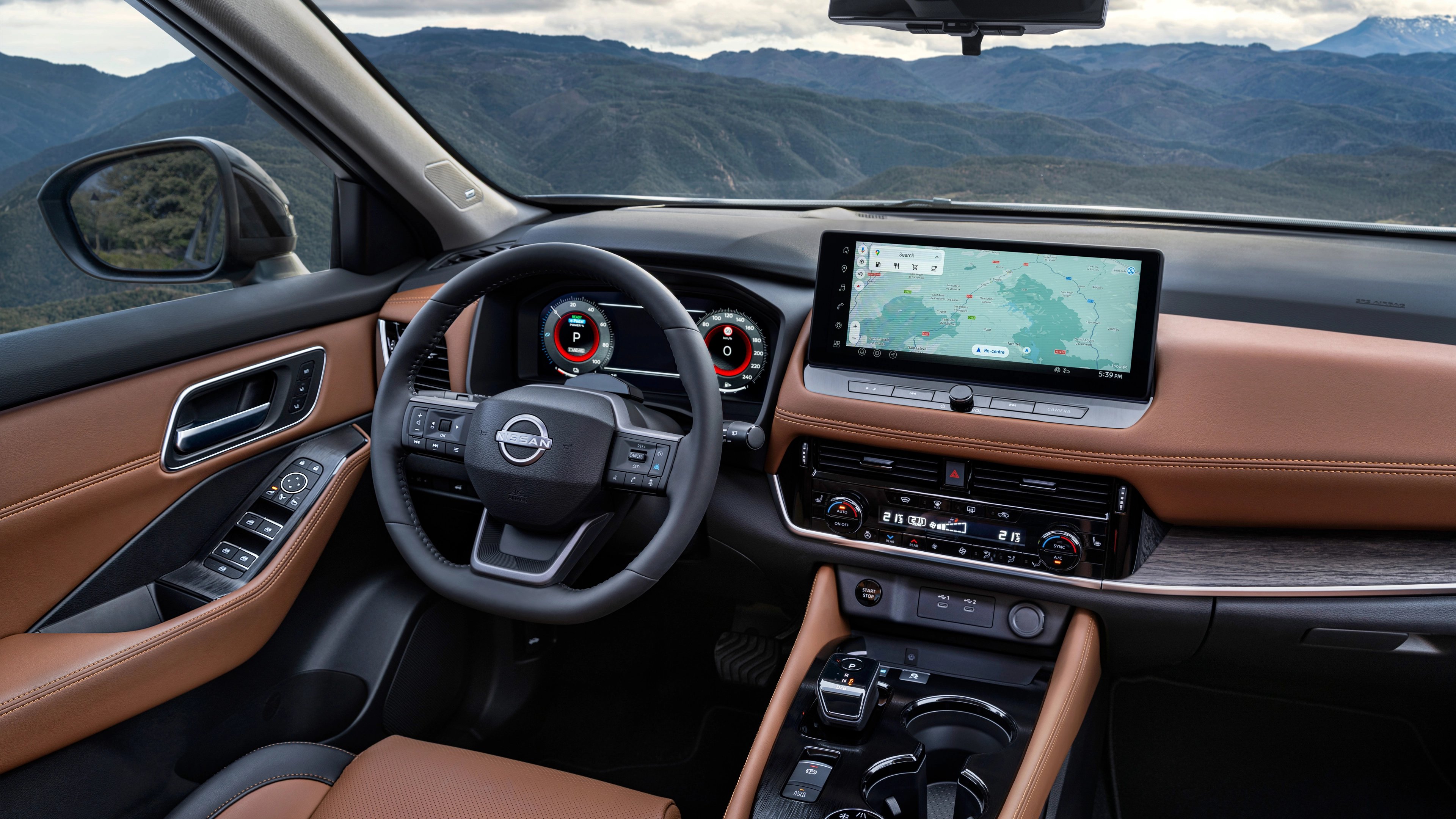 Car interior with brown leather seats, steering wheel, and dashboard with touchscreen map display.
