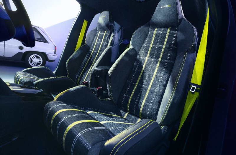 Car interior with plaid patterned sports seats and yellow seatbelts.