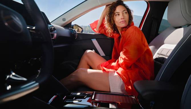 Person in a red jacket sitting in a car, looking out of the window.