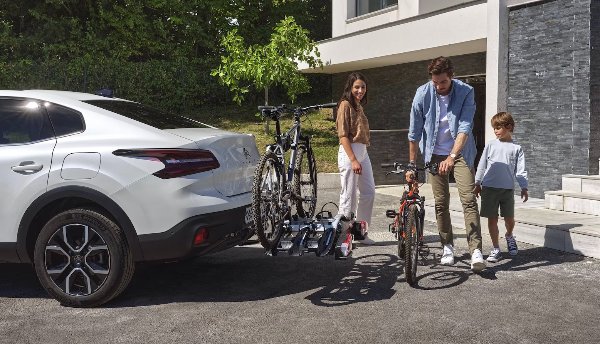 Family with bikes near an SUV with a bike rack.