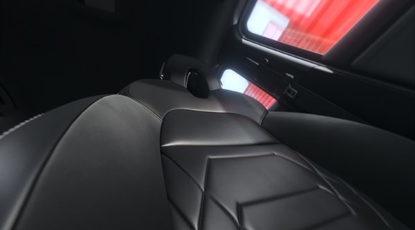 Close-up of a black leather car seat with a geometric pattern.
