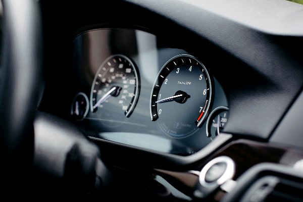 Close-up of a car dashboard with speedometer and tachometer.