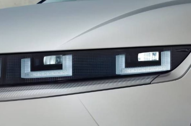 close up of the headlights of a white car