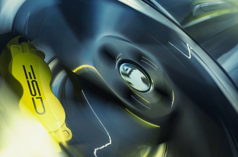 close up image of a wheel spinning with a yellow brake calliper