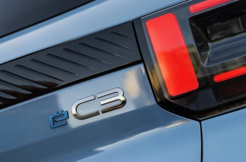 Close-up of a car's rear light and ë C3 badge on a grey body.