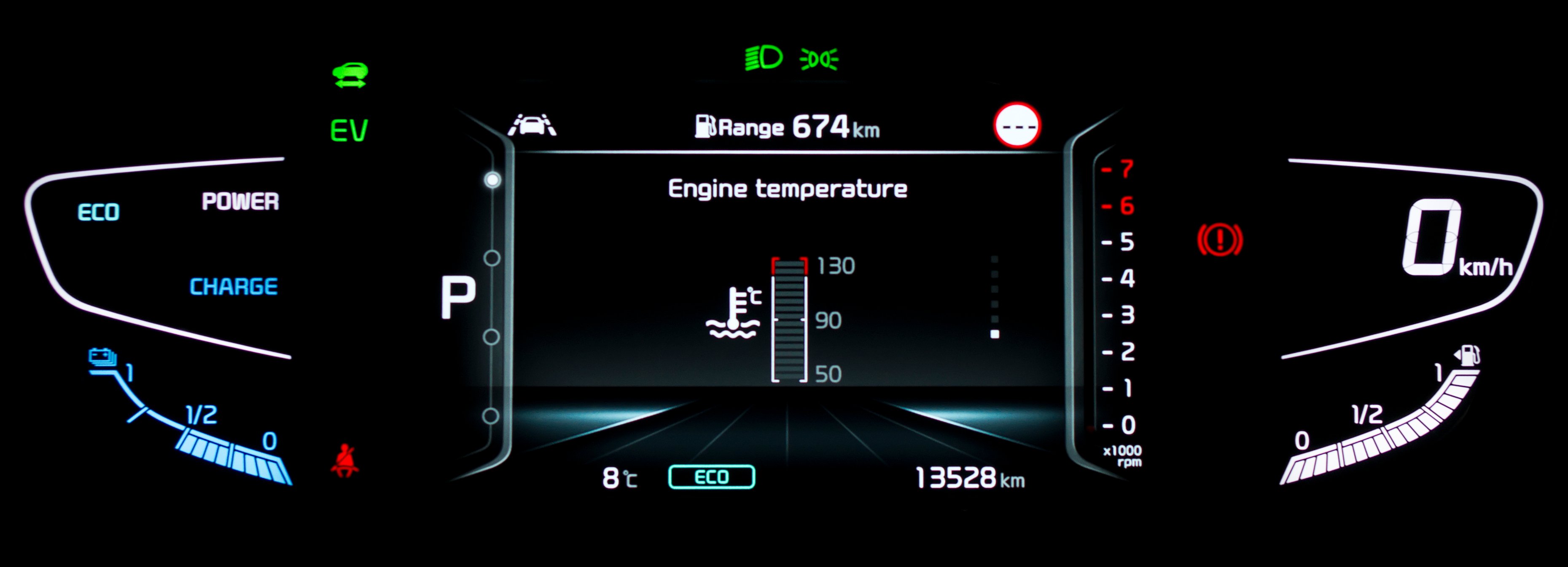Car dashboard display showing engine temperature and range of 674 km.