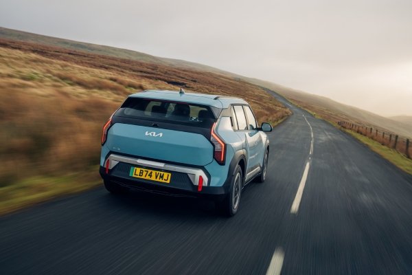 Blue SUV driving on a country road.