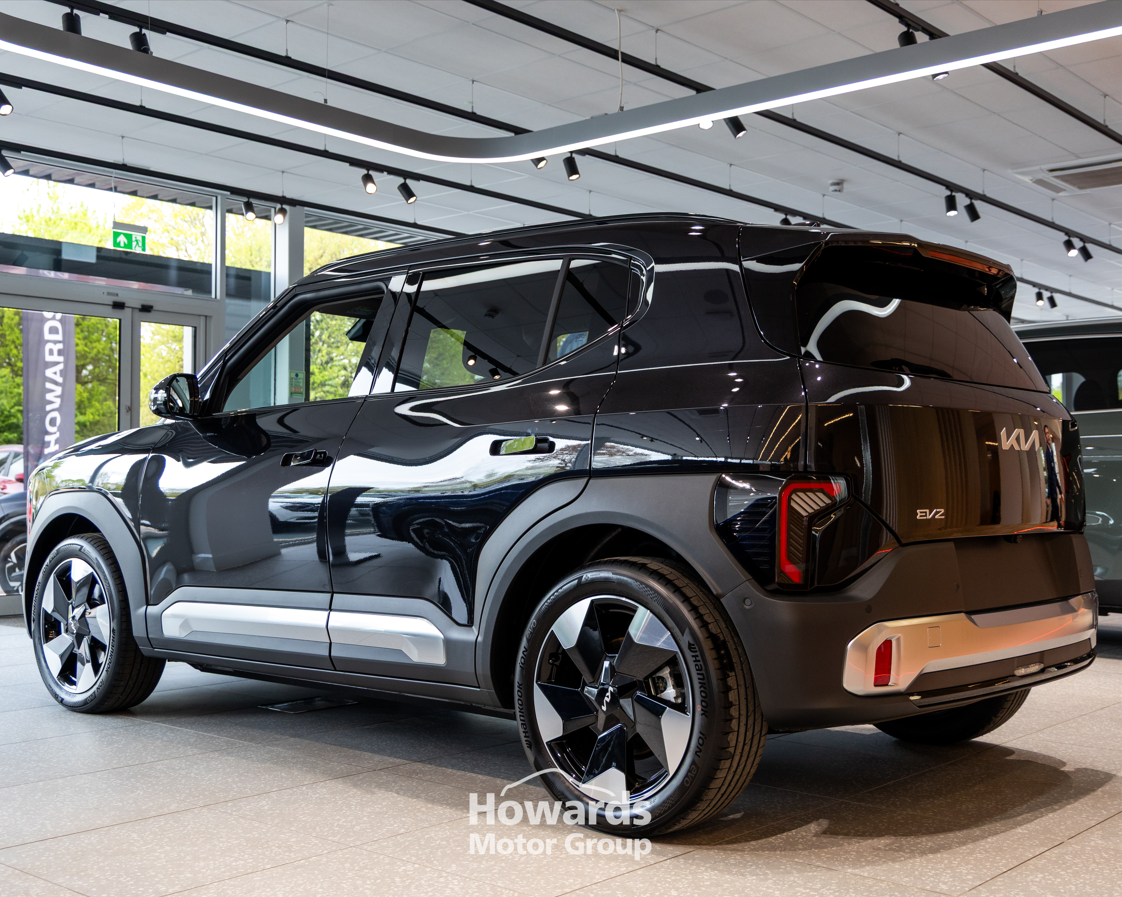A black Kia EV2 car displayed in a showroom.