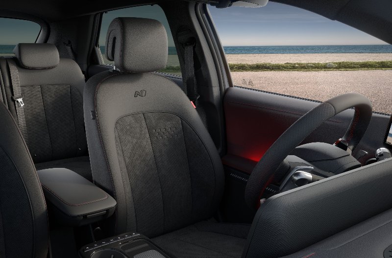Front interior view of a car with black seats and a central armrest.