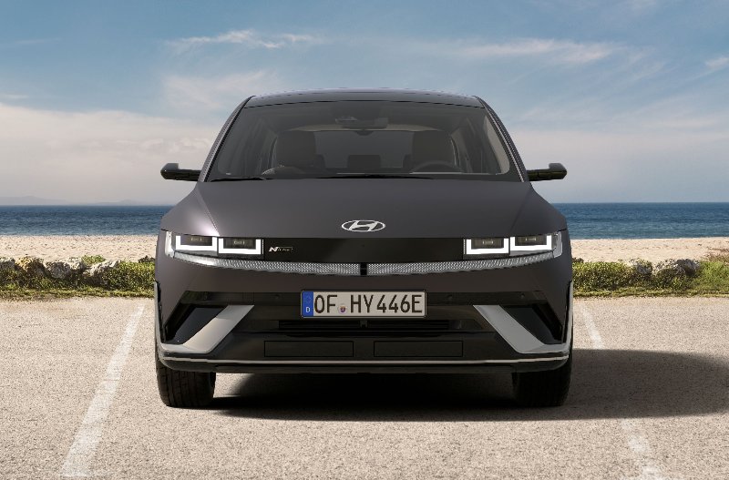 Front view of a grey Hyundai Ioniq 5 parked by the sea.