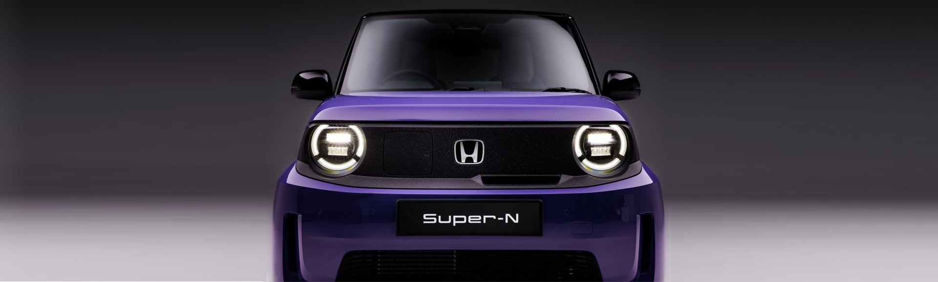 Front view of a purple Honda Super-N electric car with round headlights.