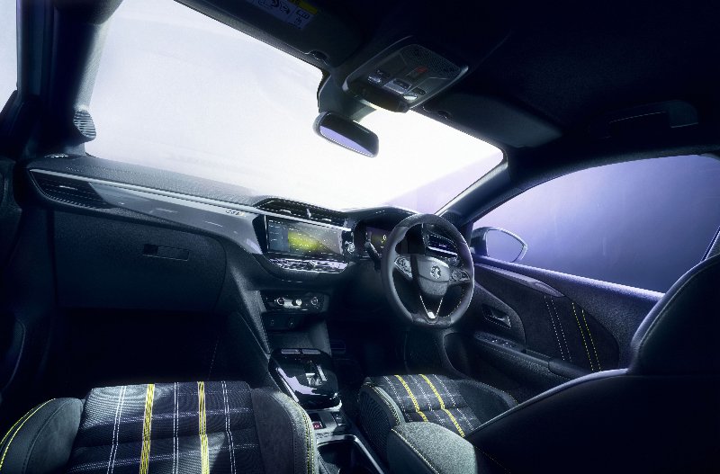 Interior of a modern car with black and yellow plaid seats and a digital dashboard.gse