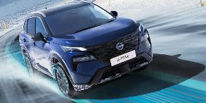 Blue Nissan X-Trail driving on a snowy road.