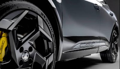 Close-up of a grey SUV's rear wheel and side panel with distinctive alloy design.