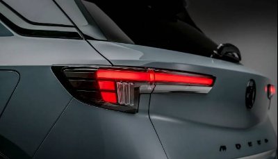 Close-up of a car's rear light with red illumination, featuring sleek design.