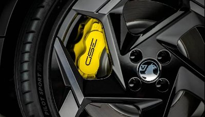 Close-up of a black alloy wheel with a yellow brake caliper.