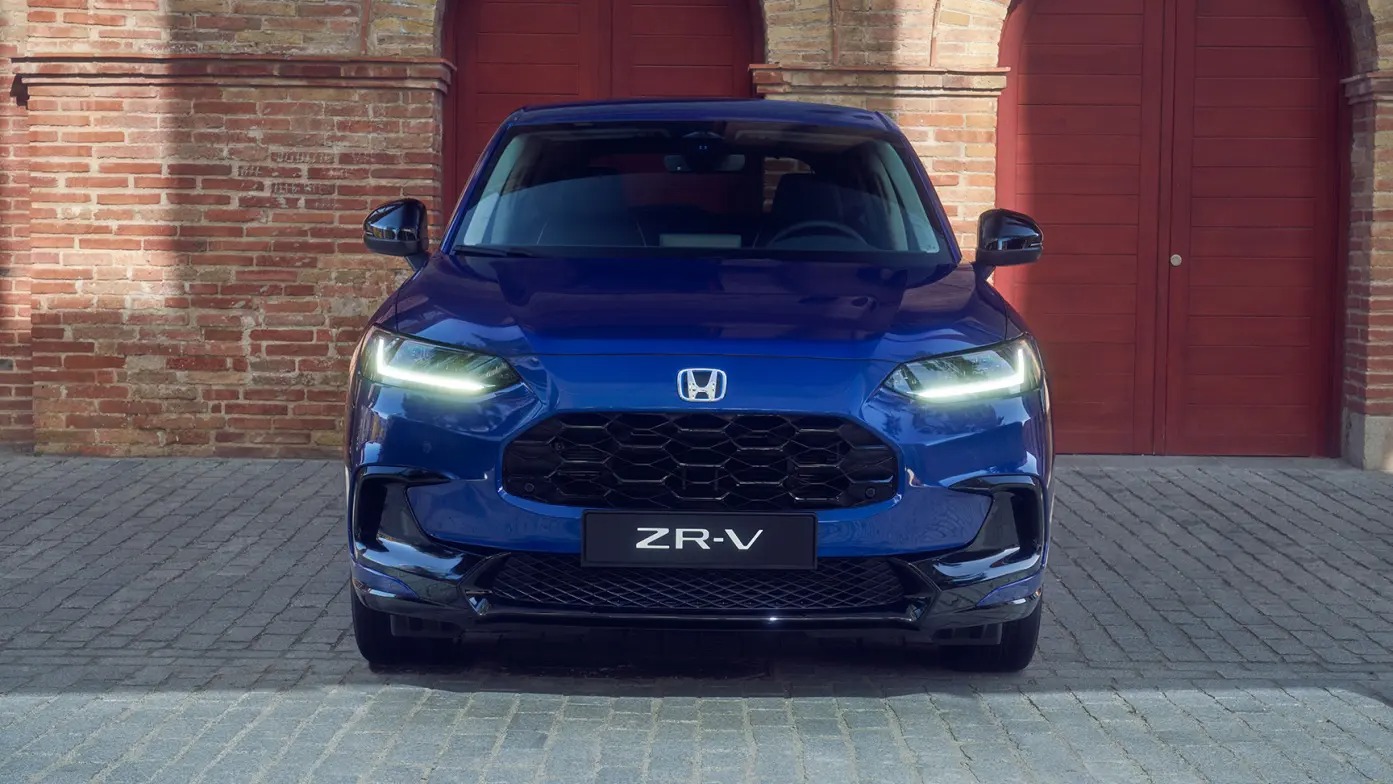Front view of a blue 2024 Honda ZR-V car with headlights on.