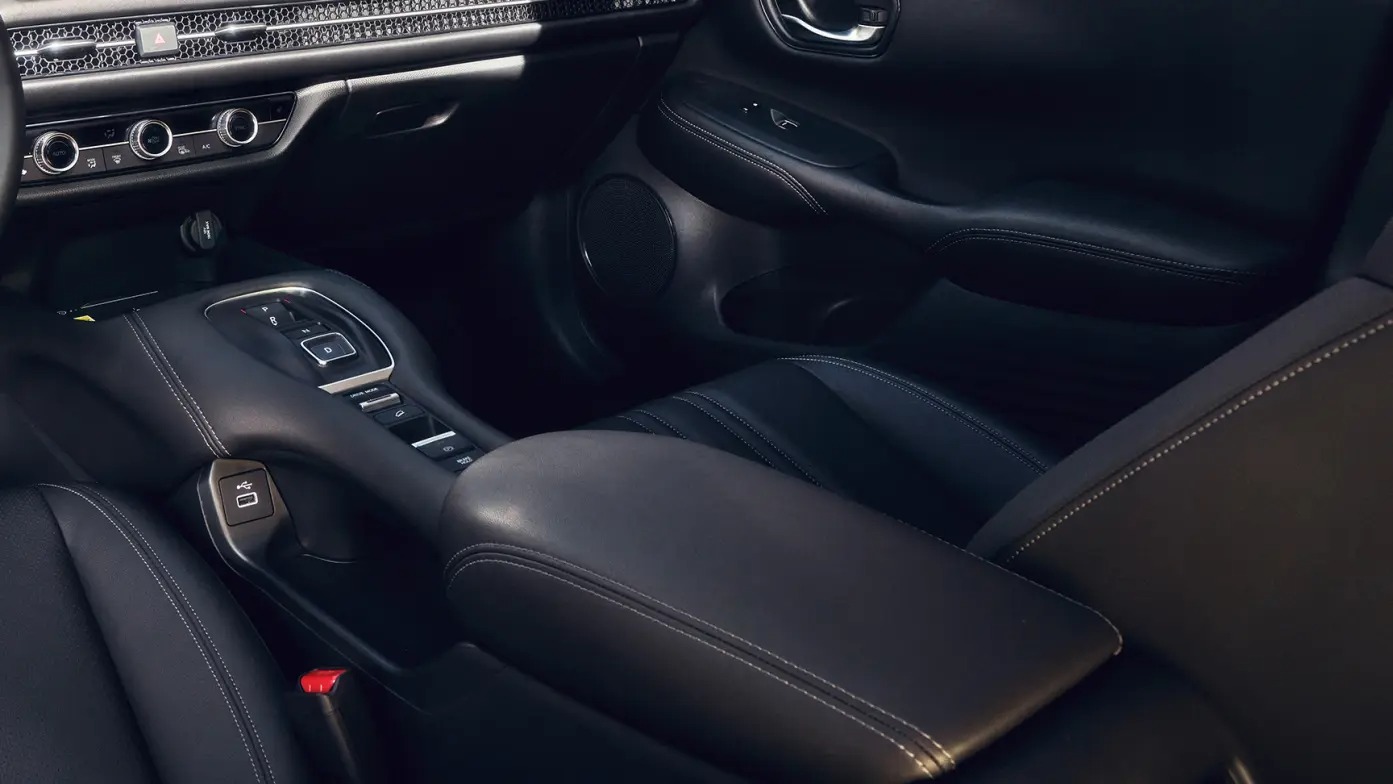 Car interior with leather seats, centre console, and dashboard controls in close-up view.
