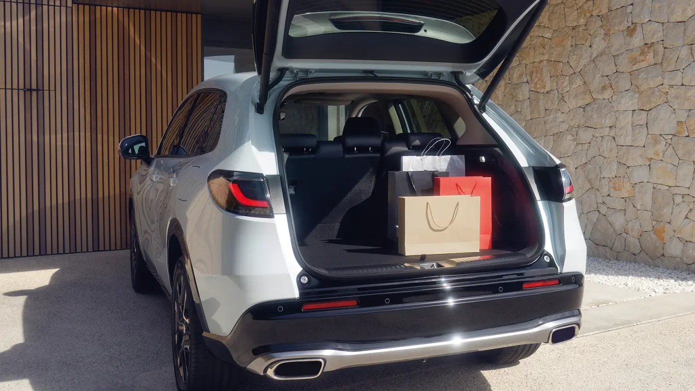 An SUV with open boot containing shopping bags.