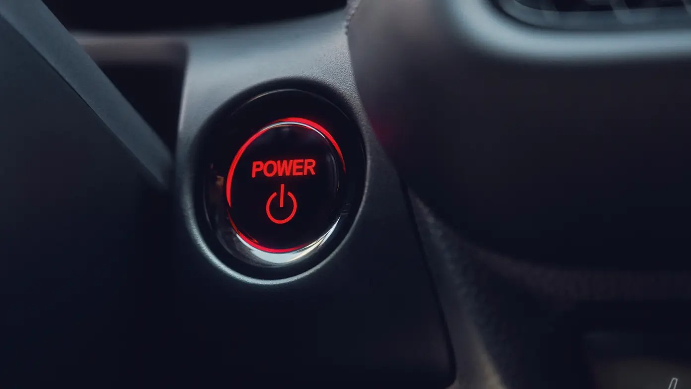 Close-up of a backlit car power button labelled Power.