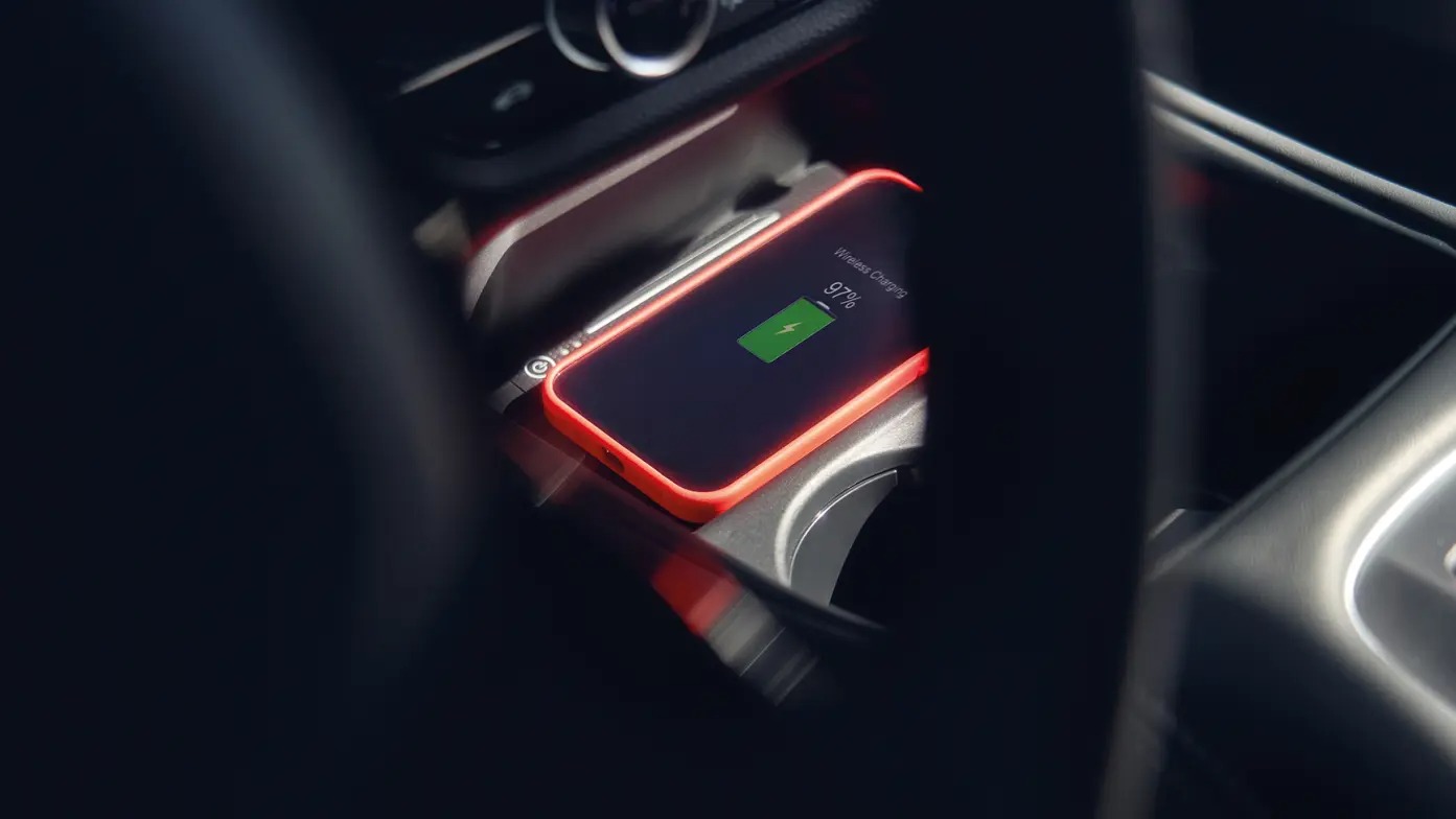 Smartphone wirelessly charging at 97% in a car's centre console.