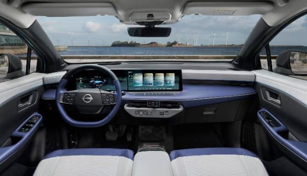 Interior of a car showing steering wheel and digital dashboard display.