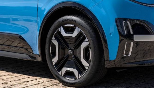 Close-up of a blue car's rear wheel with a Hankook tyre and unique black and silver alloy.