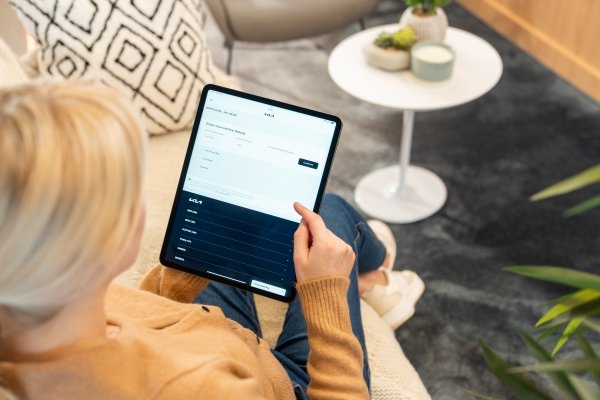 Person using a tablet with a form displayed on the screen in a home setting.