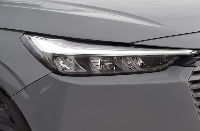 Close-up of a car's front headlight and grille.