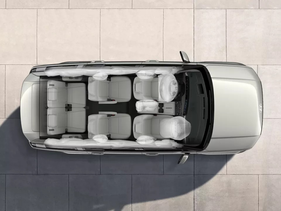 Top view of a vehicle interior showing seat arrangement and airbags deployed.