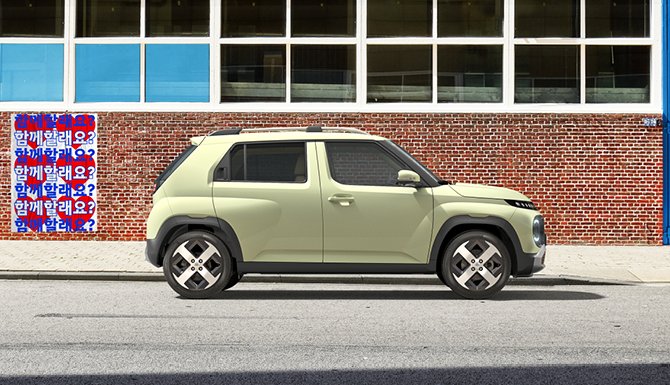 A cream-coloured compact SUV parked on a street beside a red brick wall.