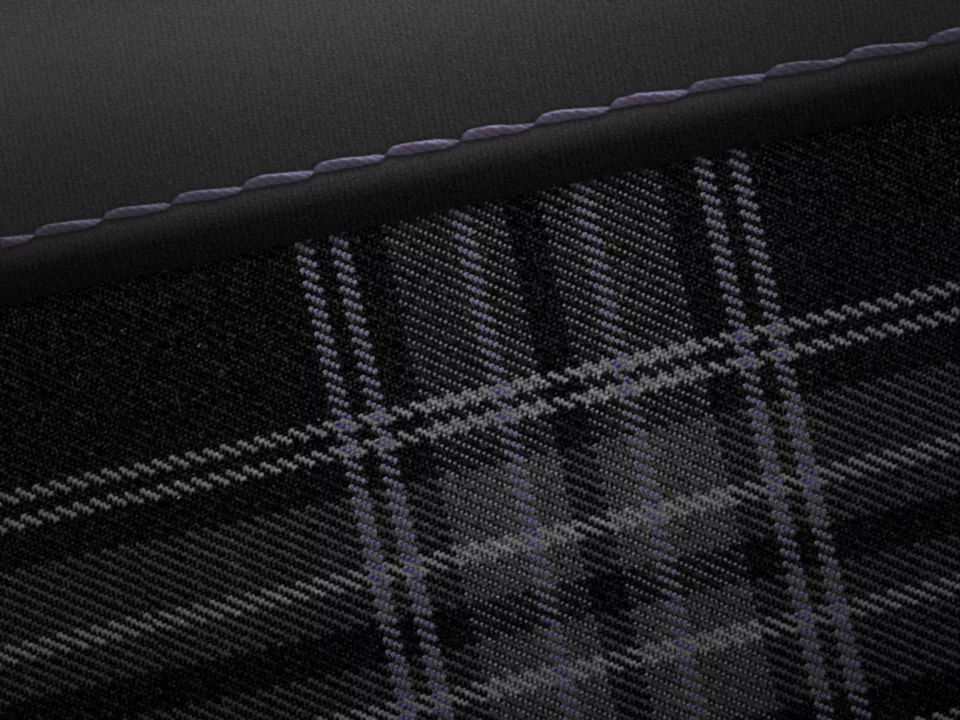 Close-up of a black and grey tartan fabric with detailed stitching.