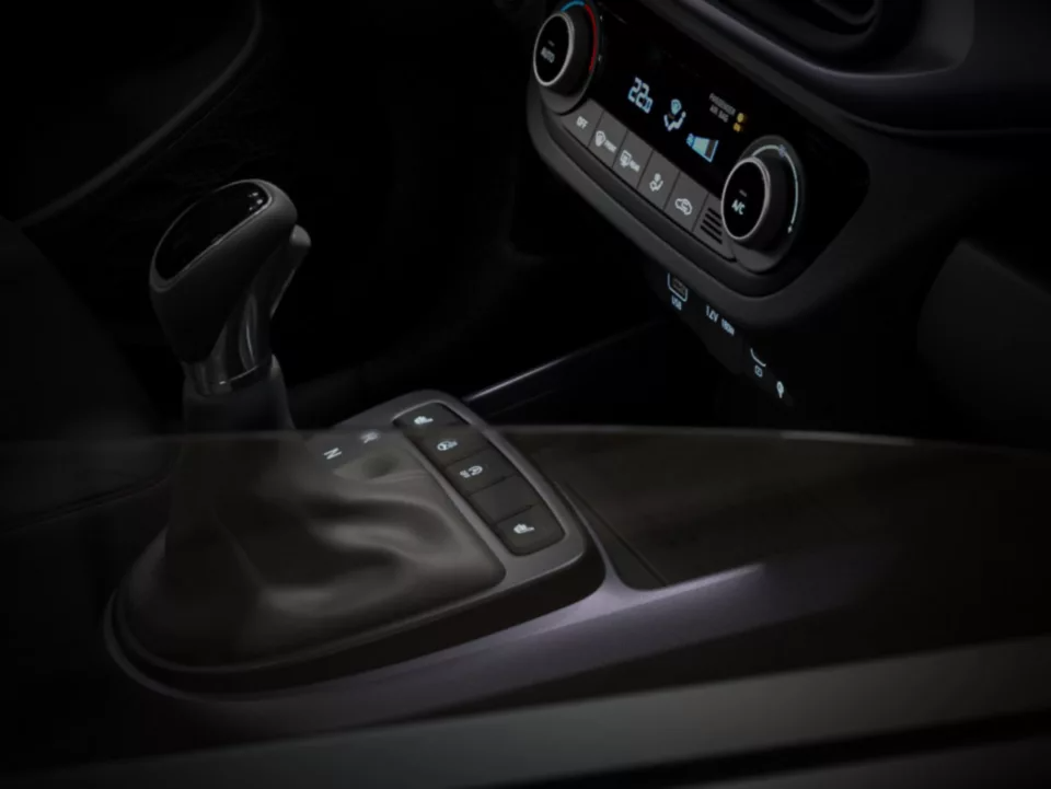 Gear stick and climate control panel in a car interior.