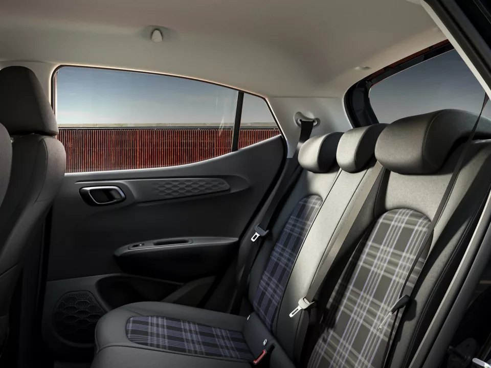 Rear car seats with plaid upholstery and door interior.