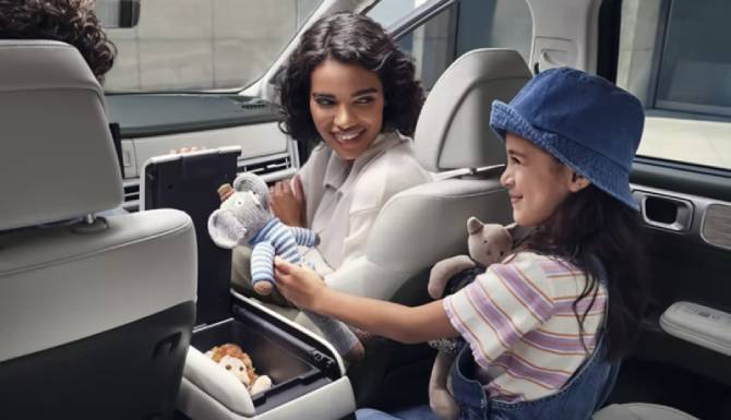 woman and child sat laughing in car
