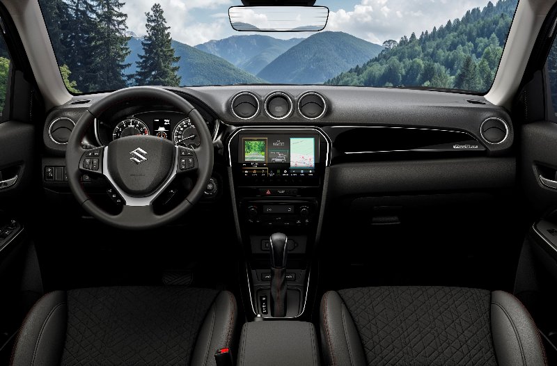 Interior view of a car dashboard with a steering wheel and digital displays.