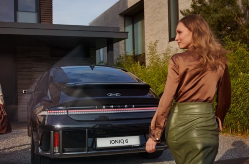 Woman walking past the back of the car